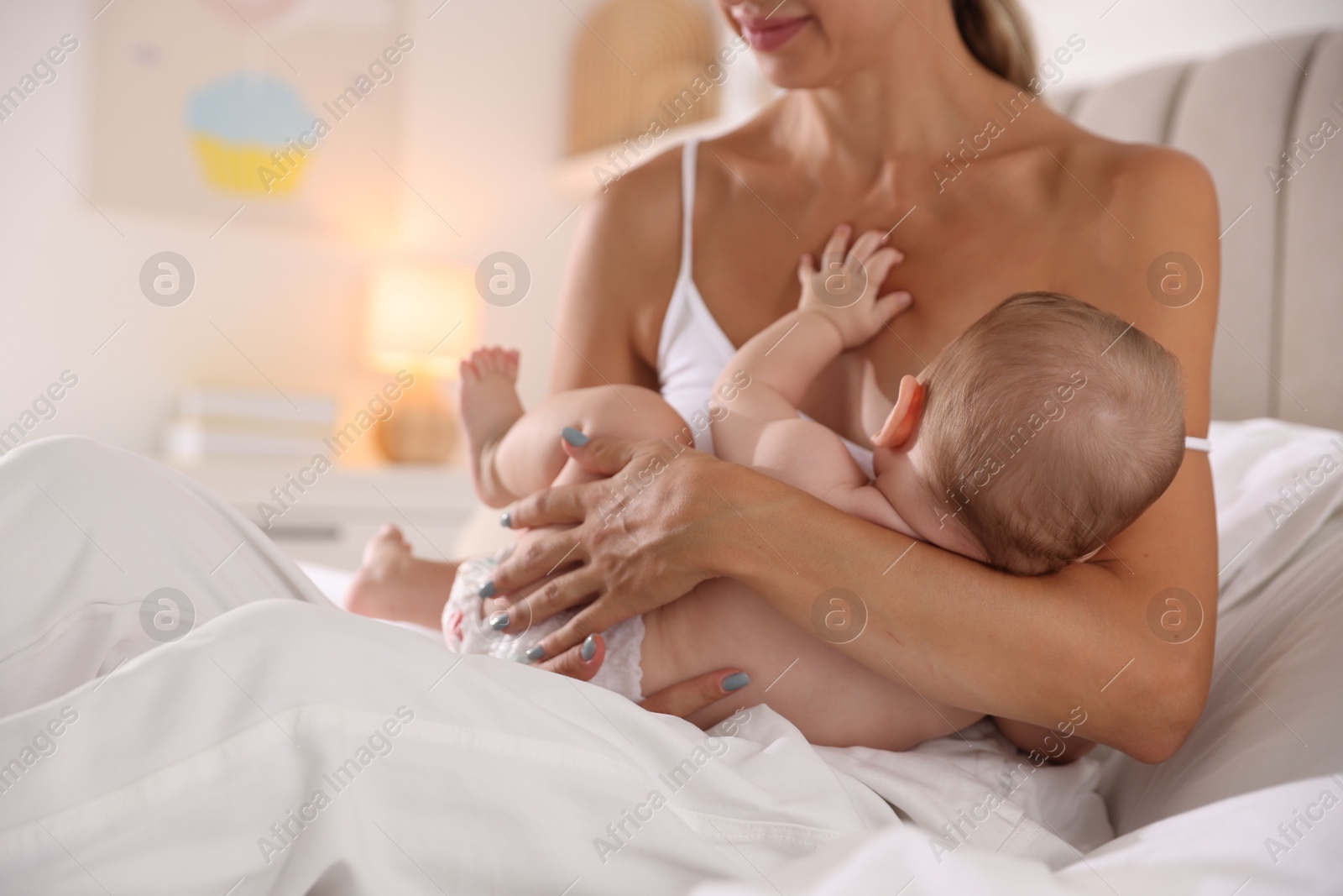 Photo of Mother breastfeeding her little baby indoors, closeup