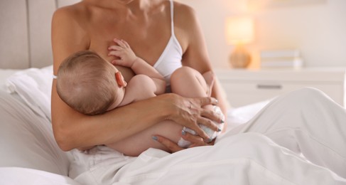 Mother breastfeeding her little baby indoors, closeup