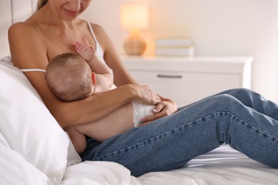 Mother breastfeeding her little baby indoors, closeup