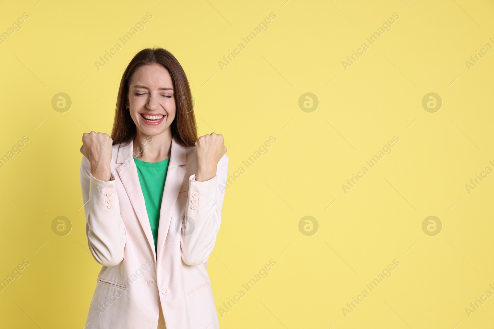 Photo of Happy winner on yellow background, space for text