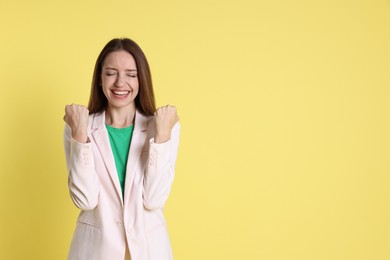 Photo of Happy winner on yellow background, space for text