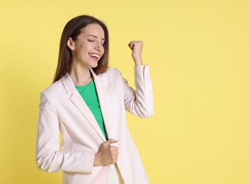 Photo of Happy winner on yellow background, space for text