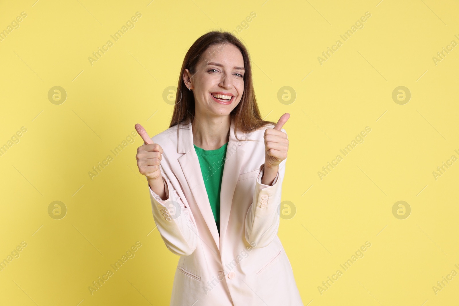 Photo of Happy winner showing thumbs up on yellow background