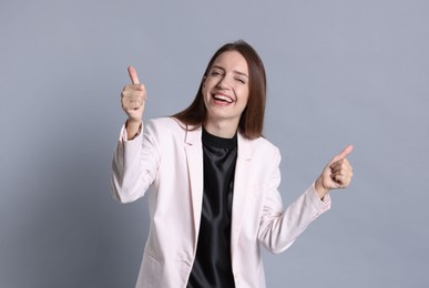 Happy winner showing thumbs up on gray background