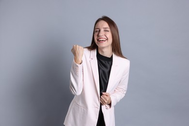 Portrait of happy winner on gray background