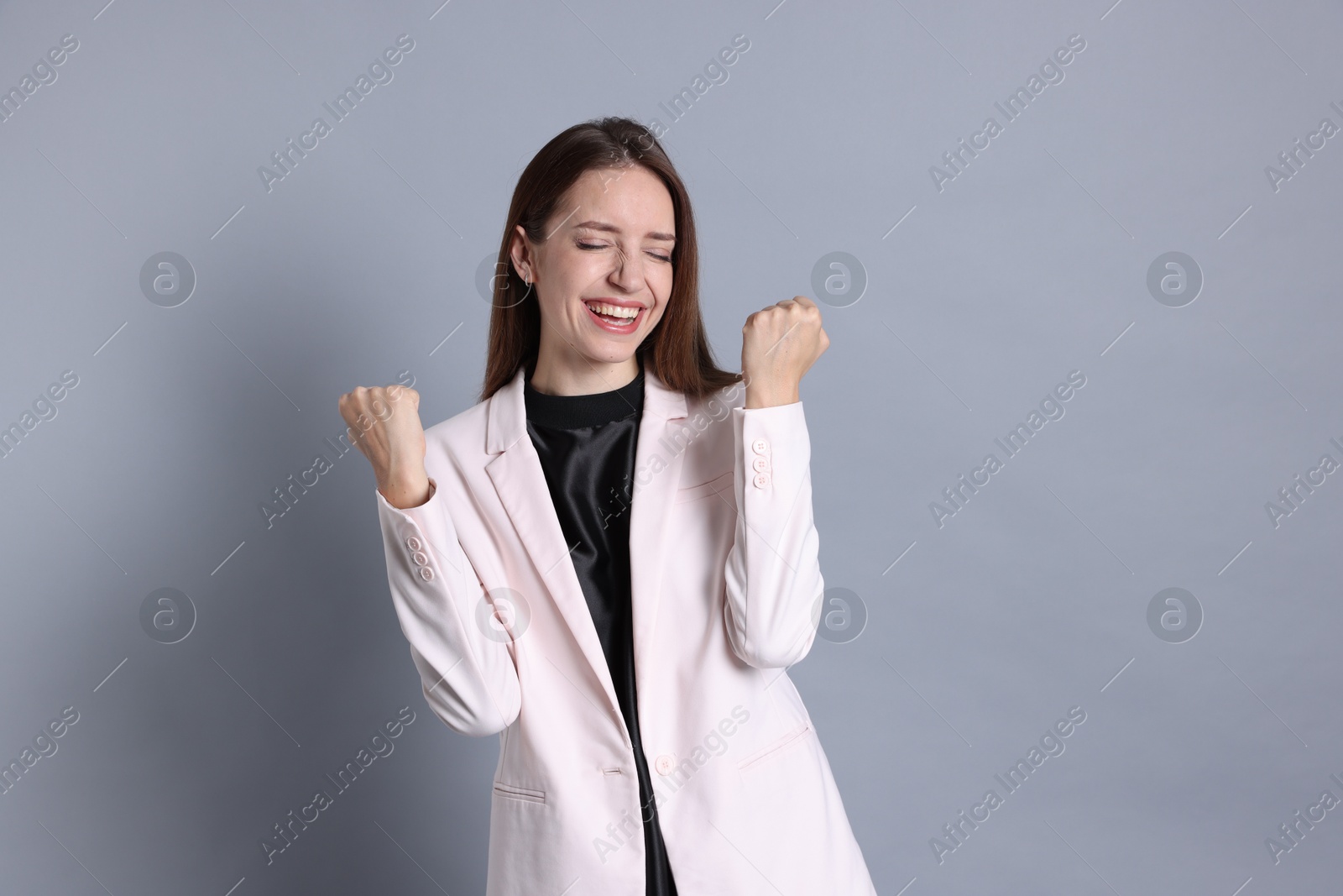 Photo of Portrait of happy winner on gray background