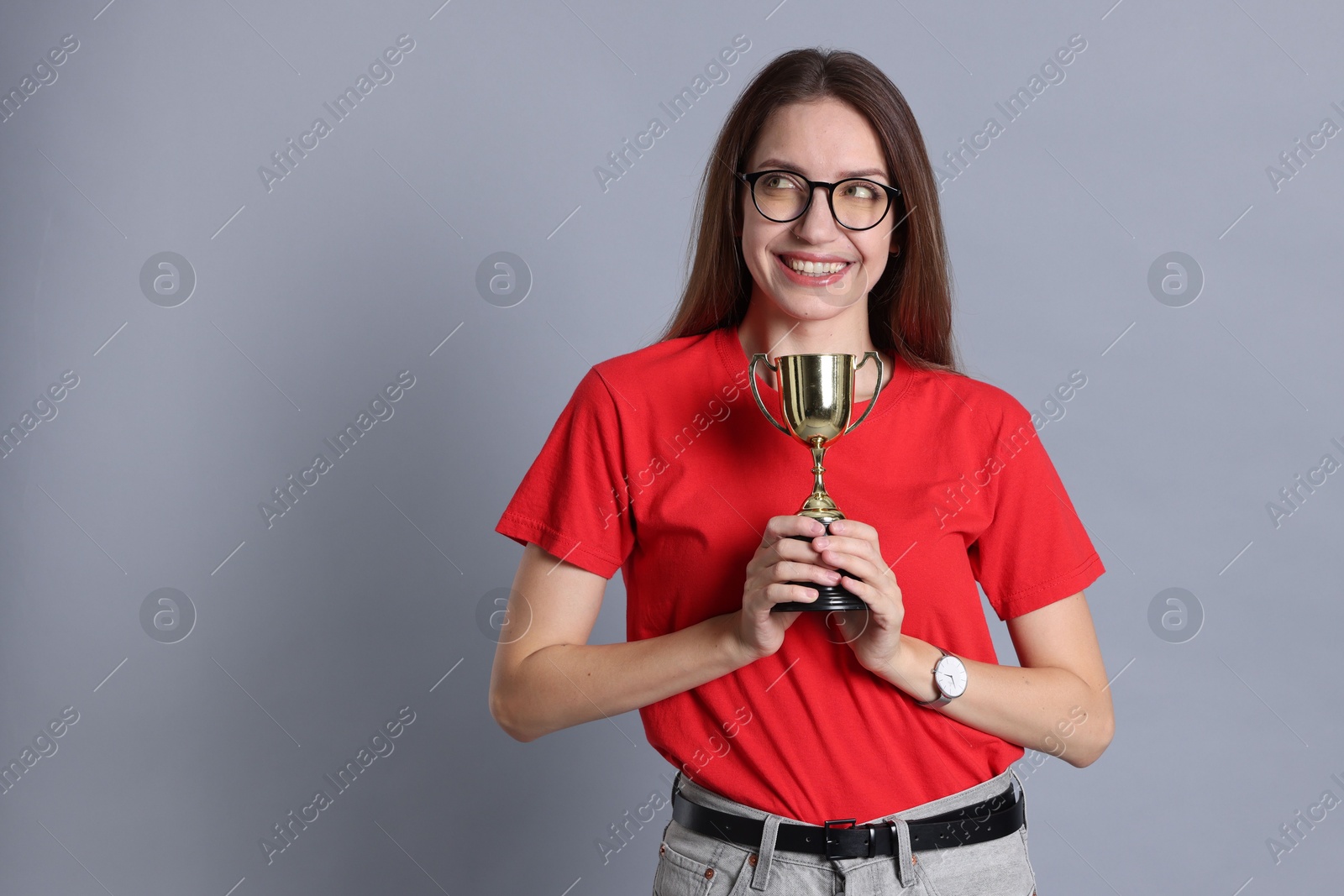 Photo of Happy winner with gold trophy cup on gray background