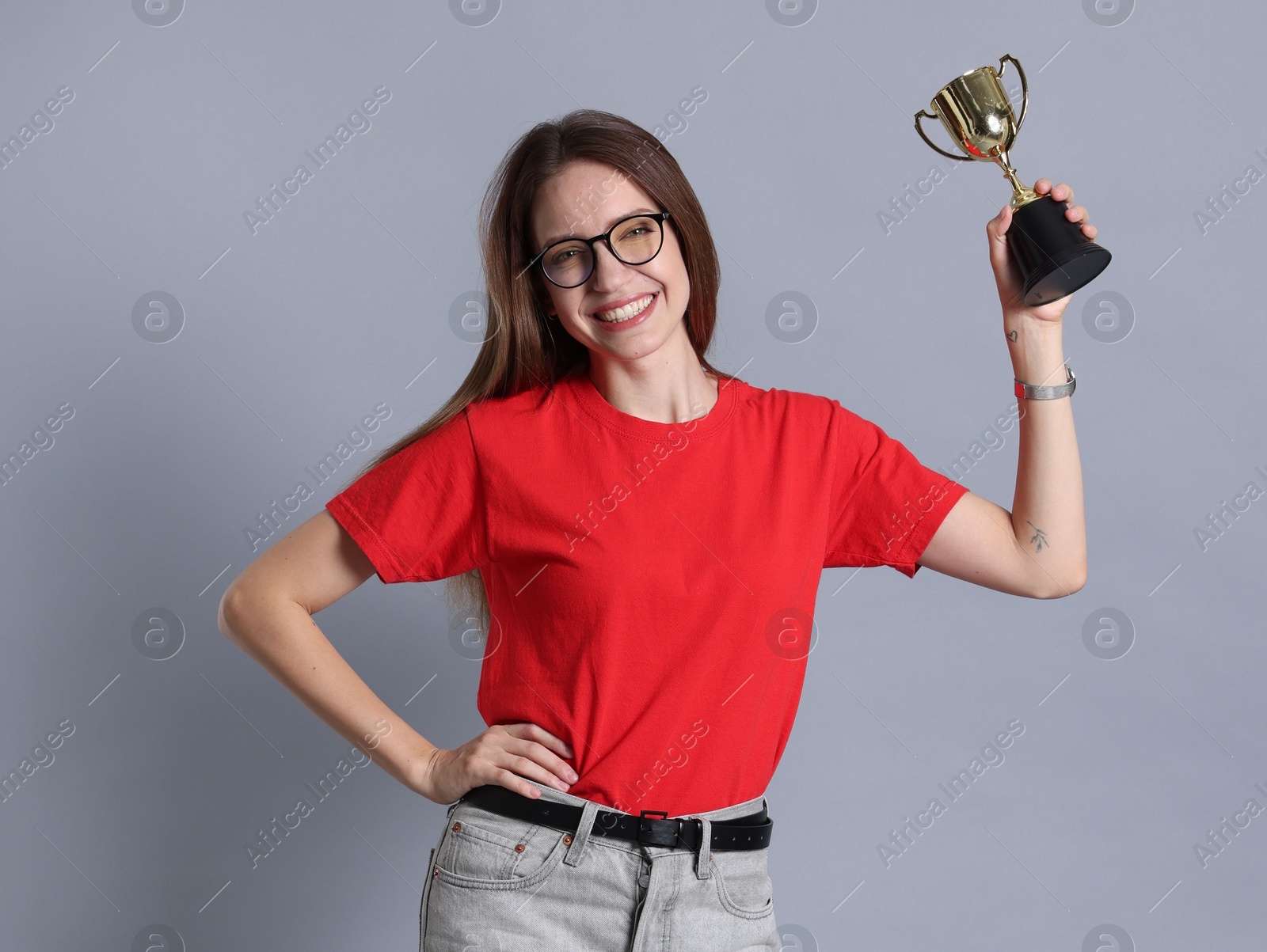 Photo of Happy winner with gold trophy cup on gray background