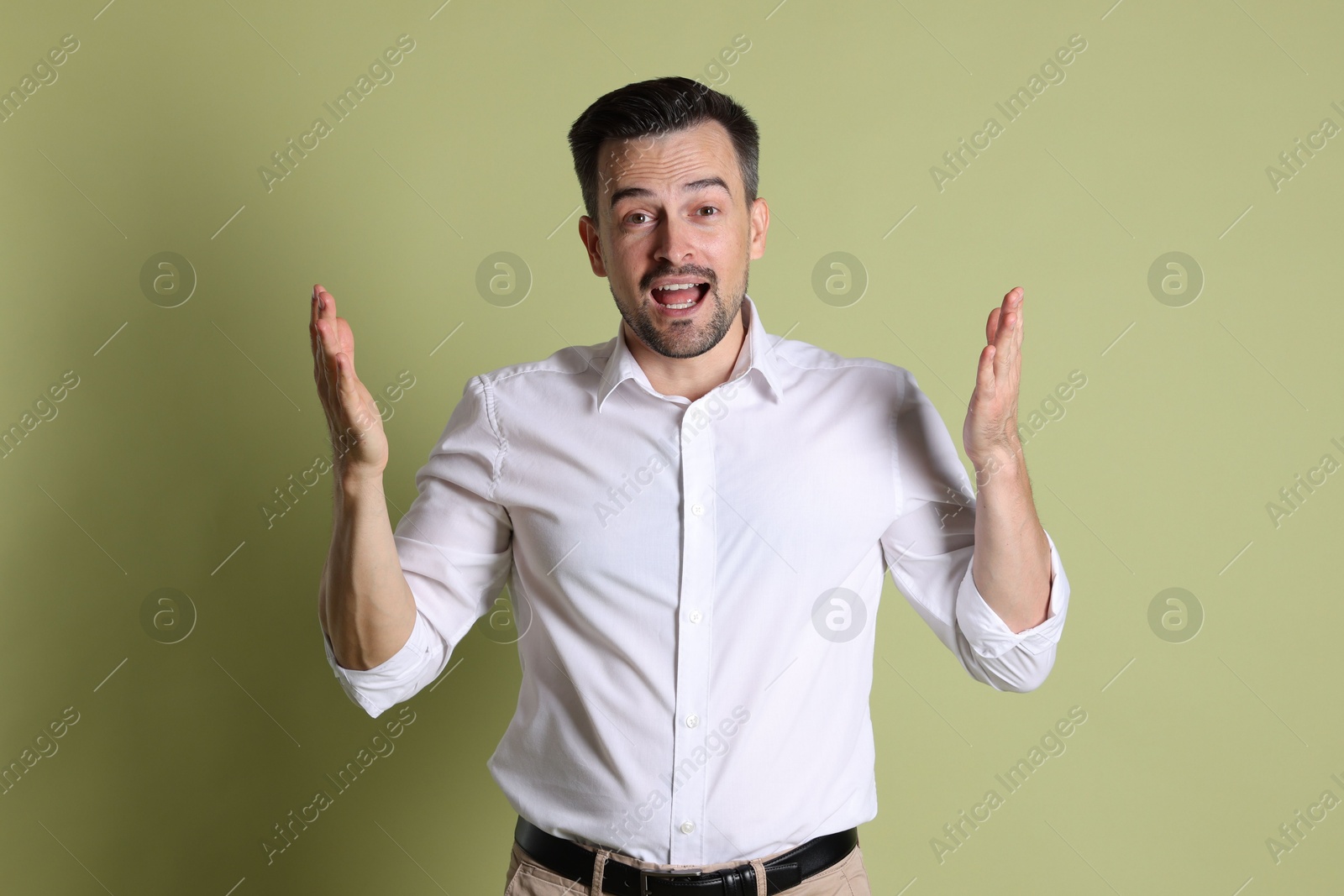 Photo of Portrait of emotional winner on pale olive background