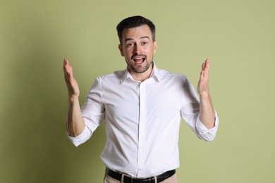 Photo of Portrait of emotional winner on pale olive background