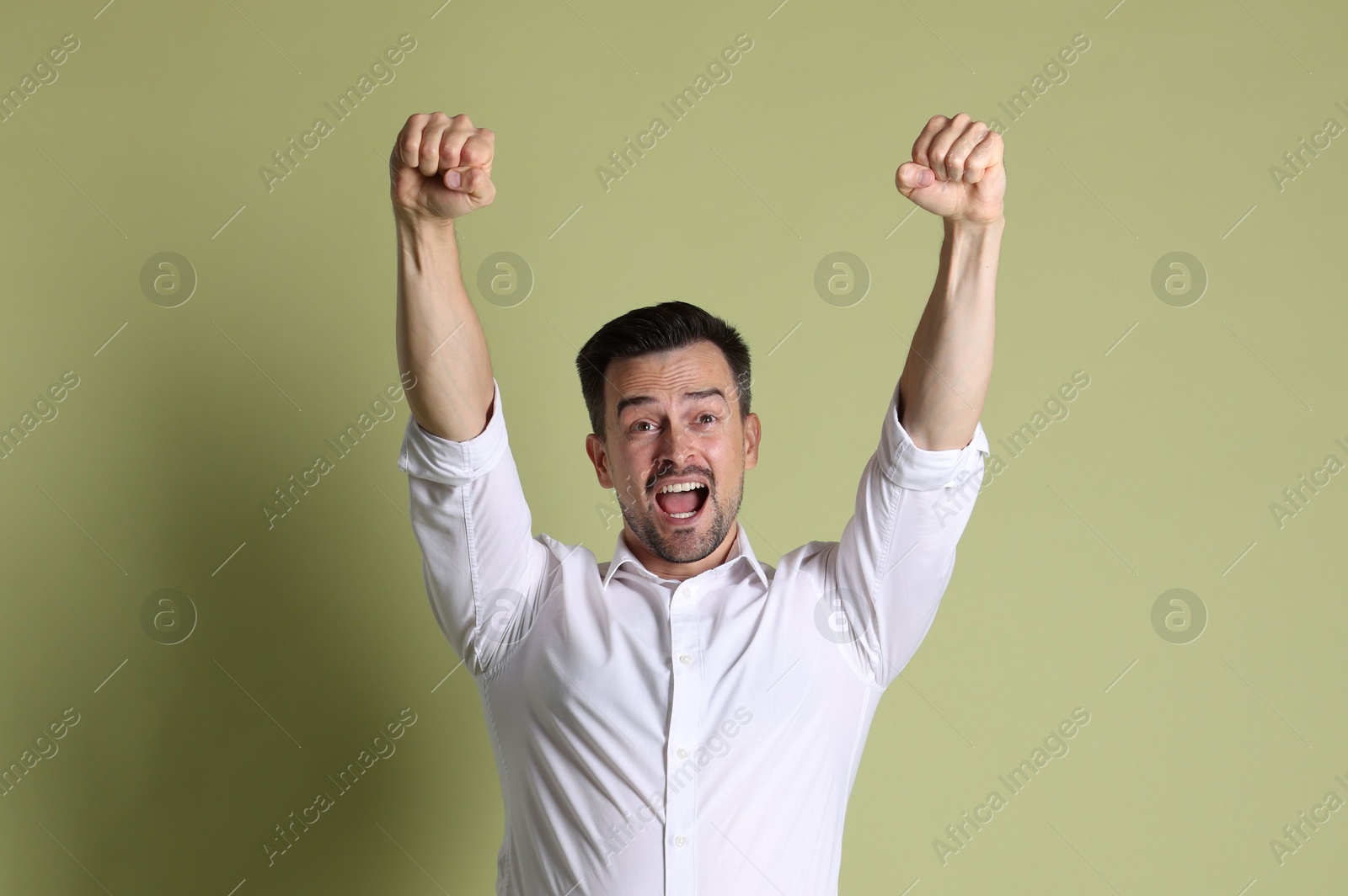 Photo of Portrait of happy winner on pale olive background