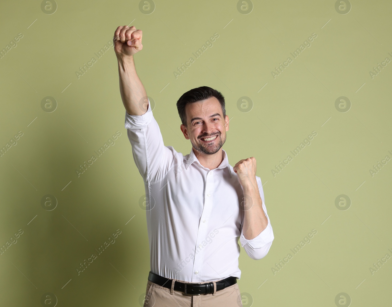 Photo of Portrait of happy winner on pale olive background