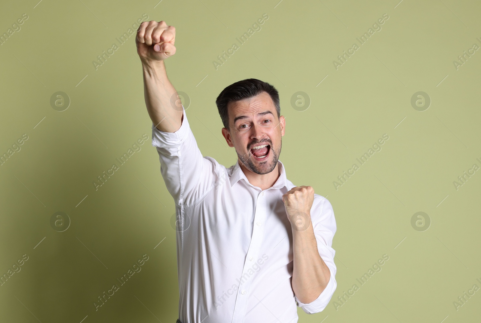 Photo of Portrait of happy winner on pale olive background