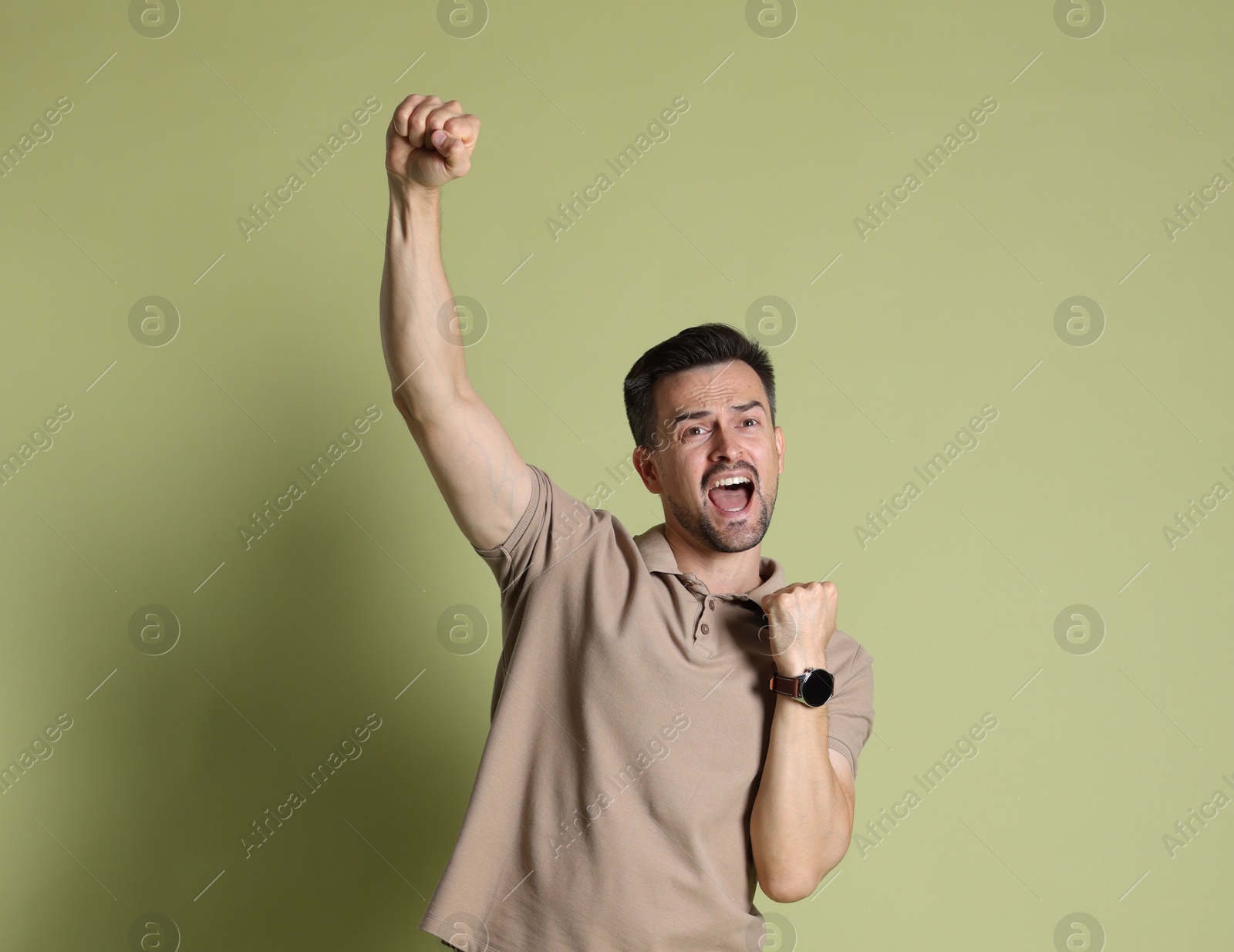 Photo of Portrait of happy winner on pale olive background