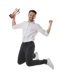 Happy winner with golden trophy cup jumping on white background