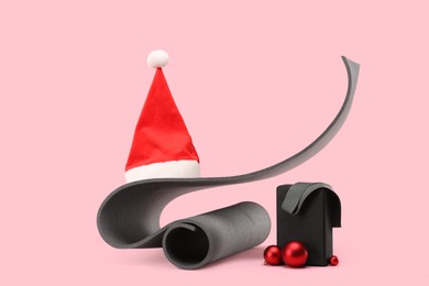 Photo of Yoga mat, block, Santa hat and baubles on pink background