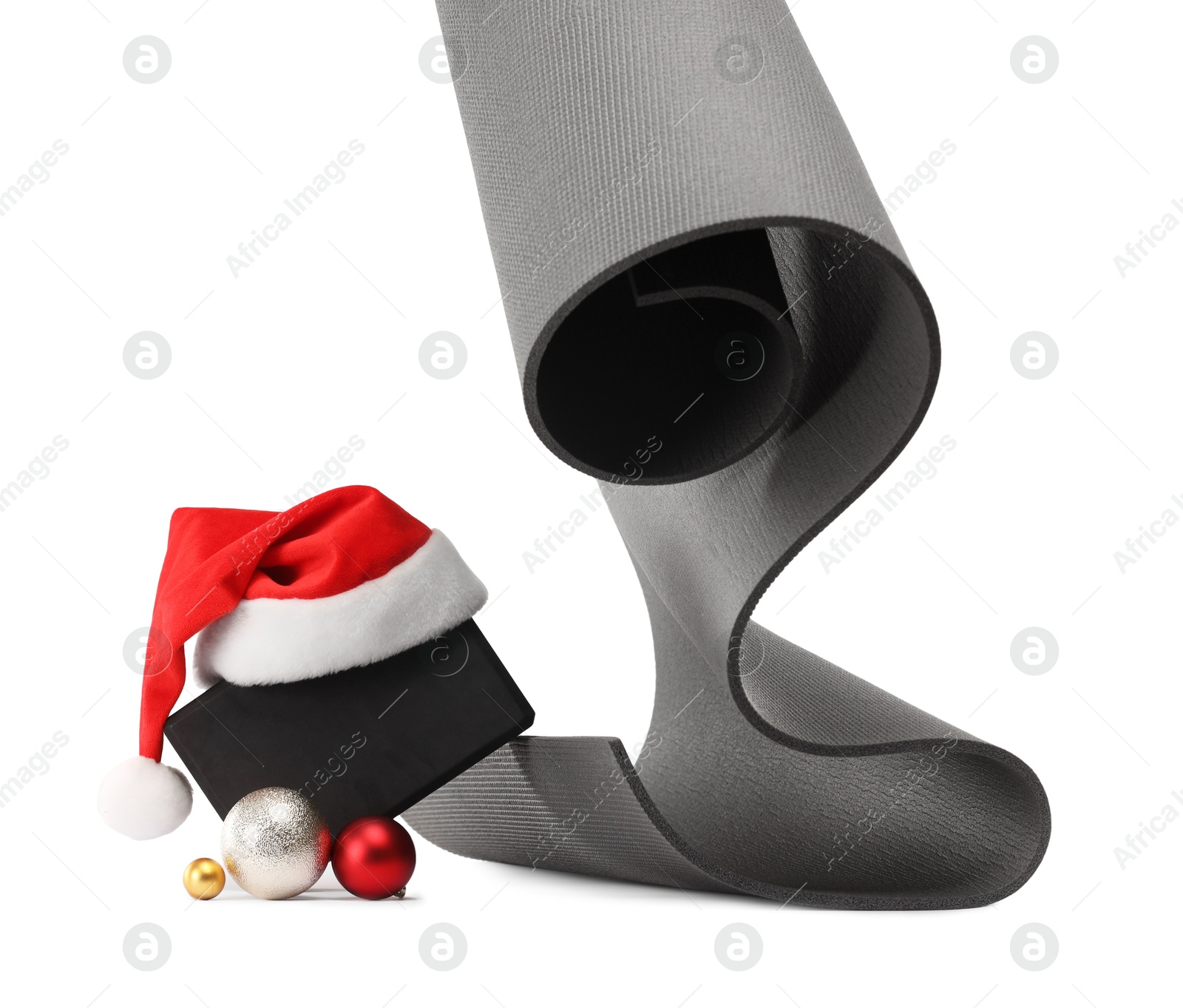 Photo of Yoga mat, block, Santa hat and baubles isolated on white