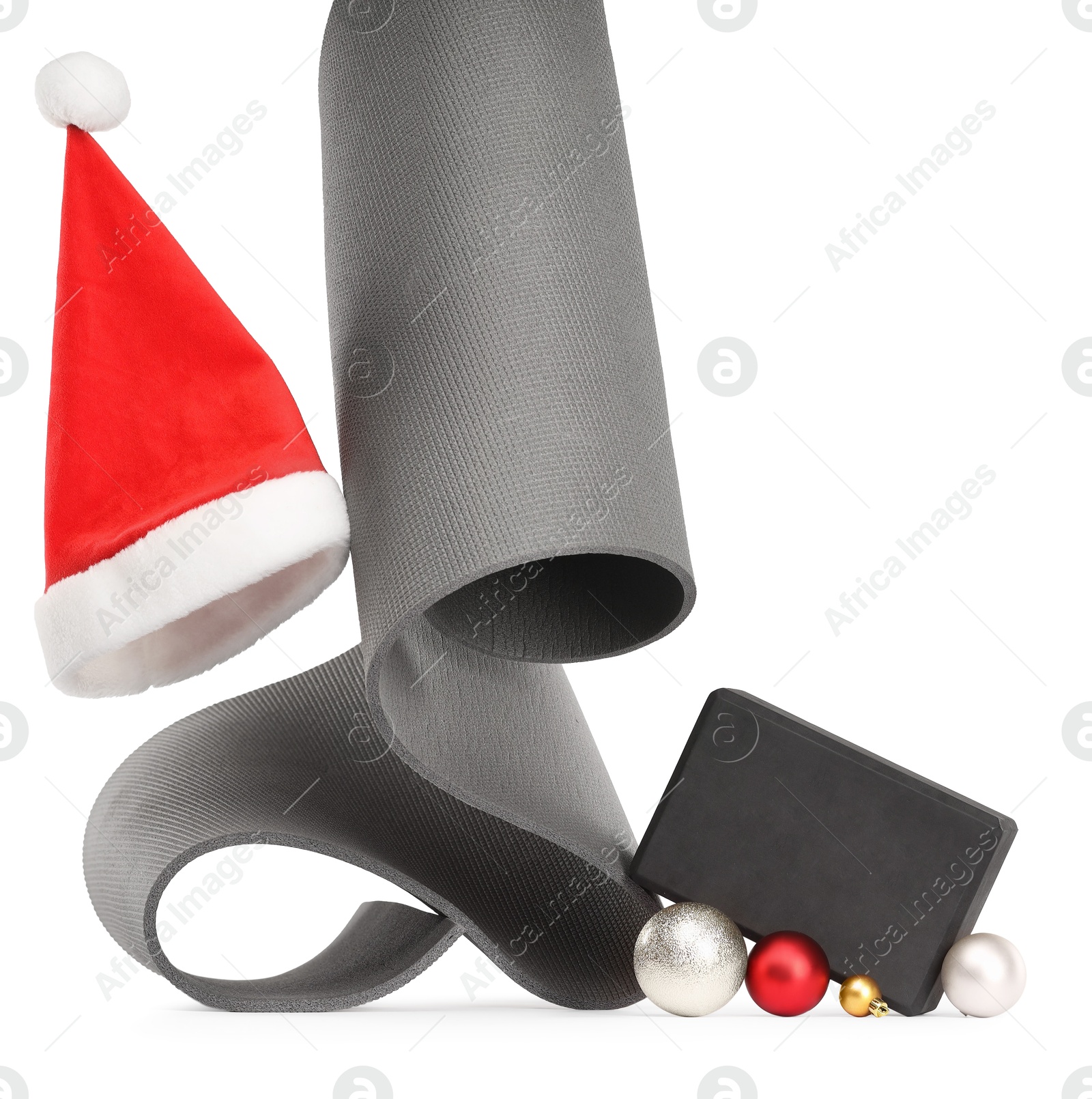 Photo of Yoga mat, block, Santa hat and baubles isolated on white