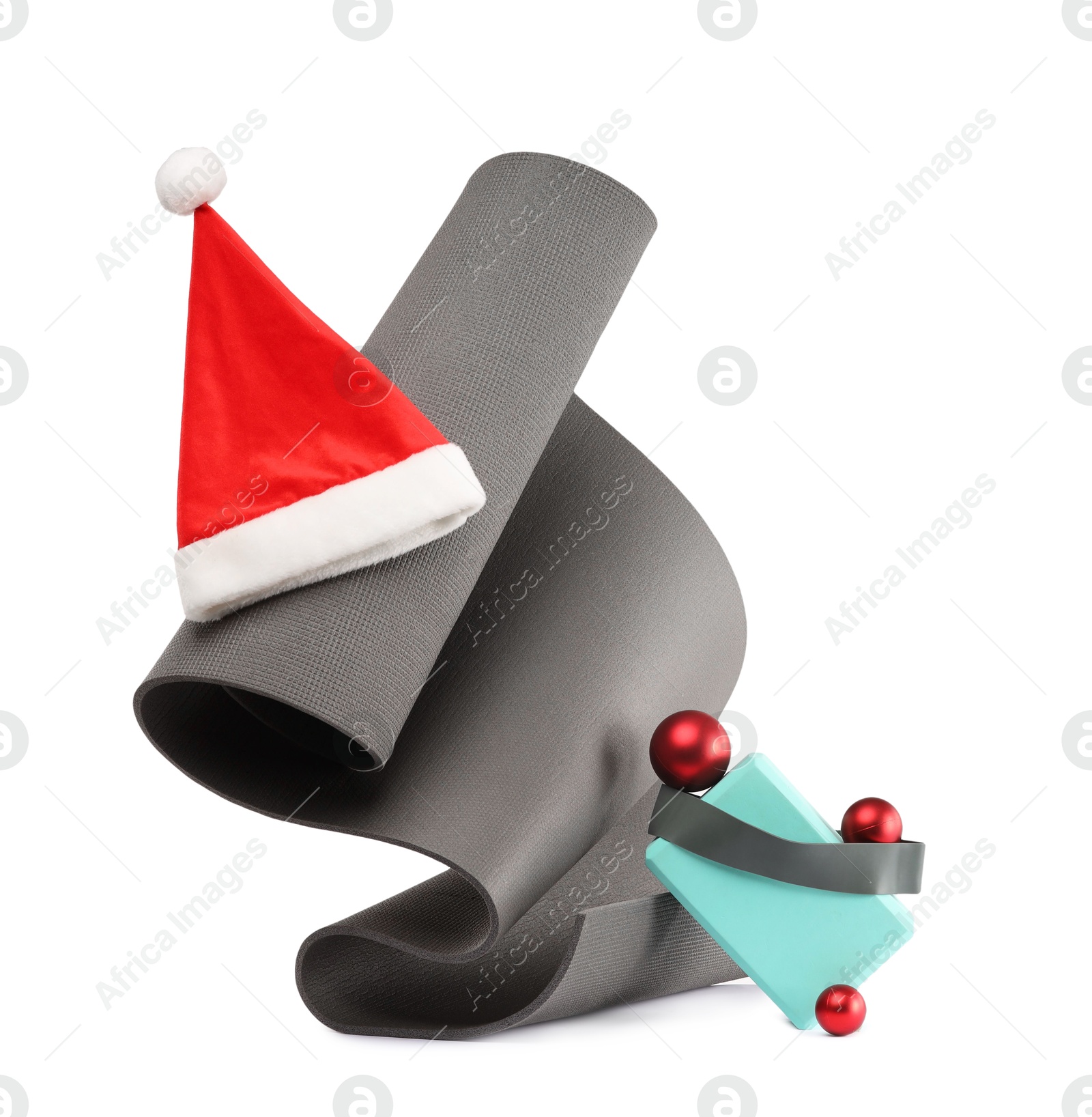 Photo of Yoga mat, block, Santa hat and baubles isolated on white