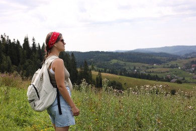 Photo of Tourist with backpack enjoying picturesque landscape. Space for text