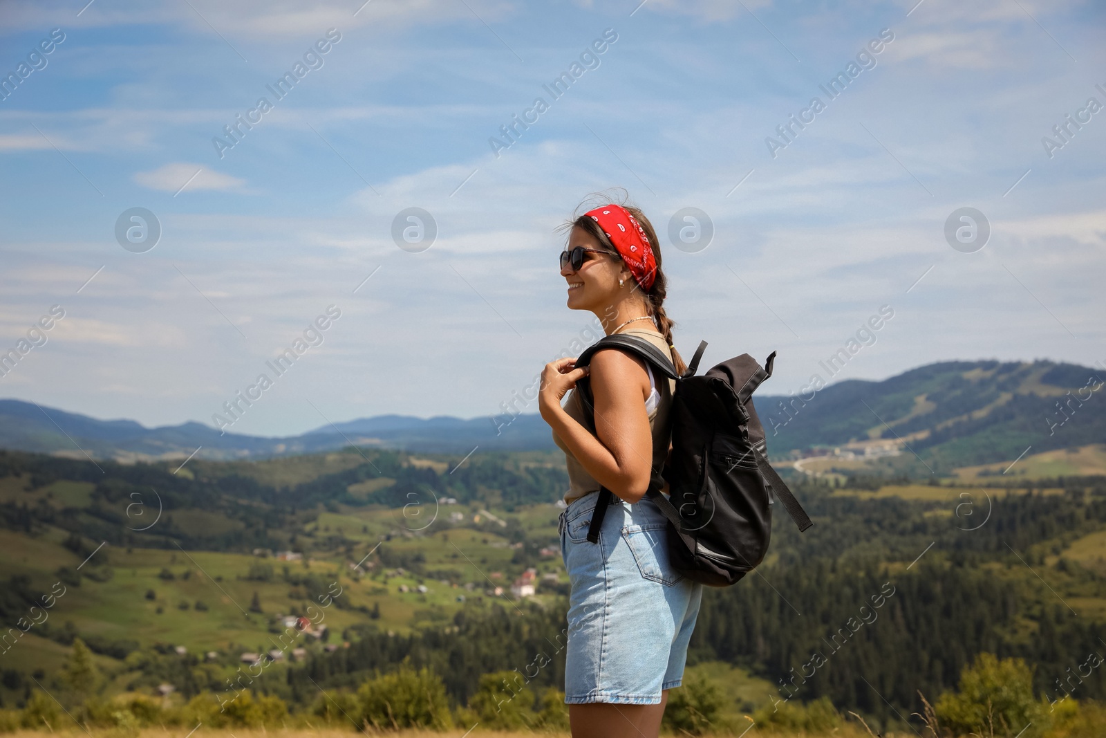 Photo of Smiling tourist with backpack enjoying picturesque landscape. Space for text