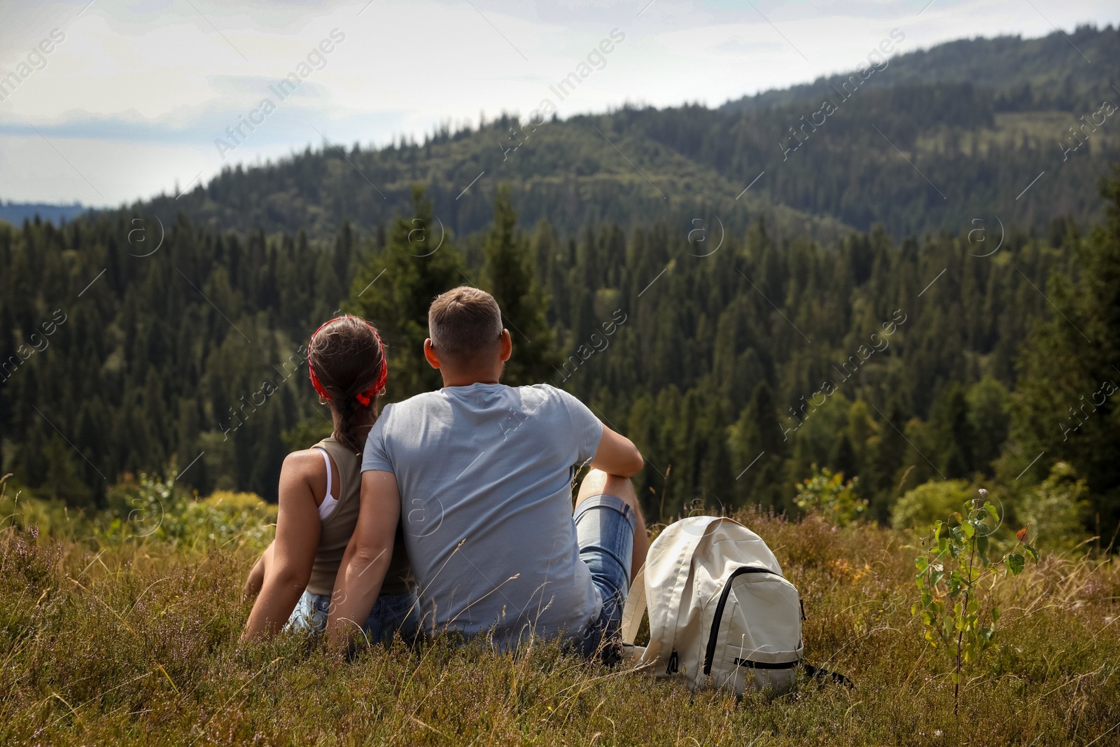 Photo of Couple with backpack enjoying picturesque landscape, back view. Active tourism