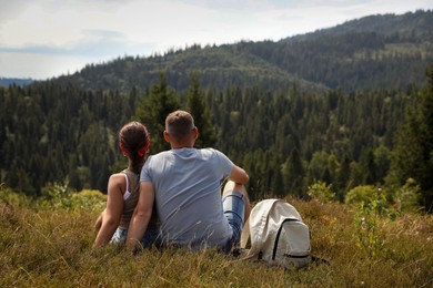 Couple with backpack enjoying picturesque landscape, back view. Active tourism