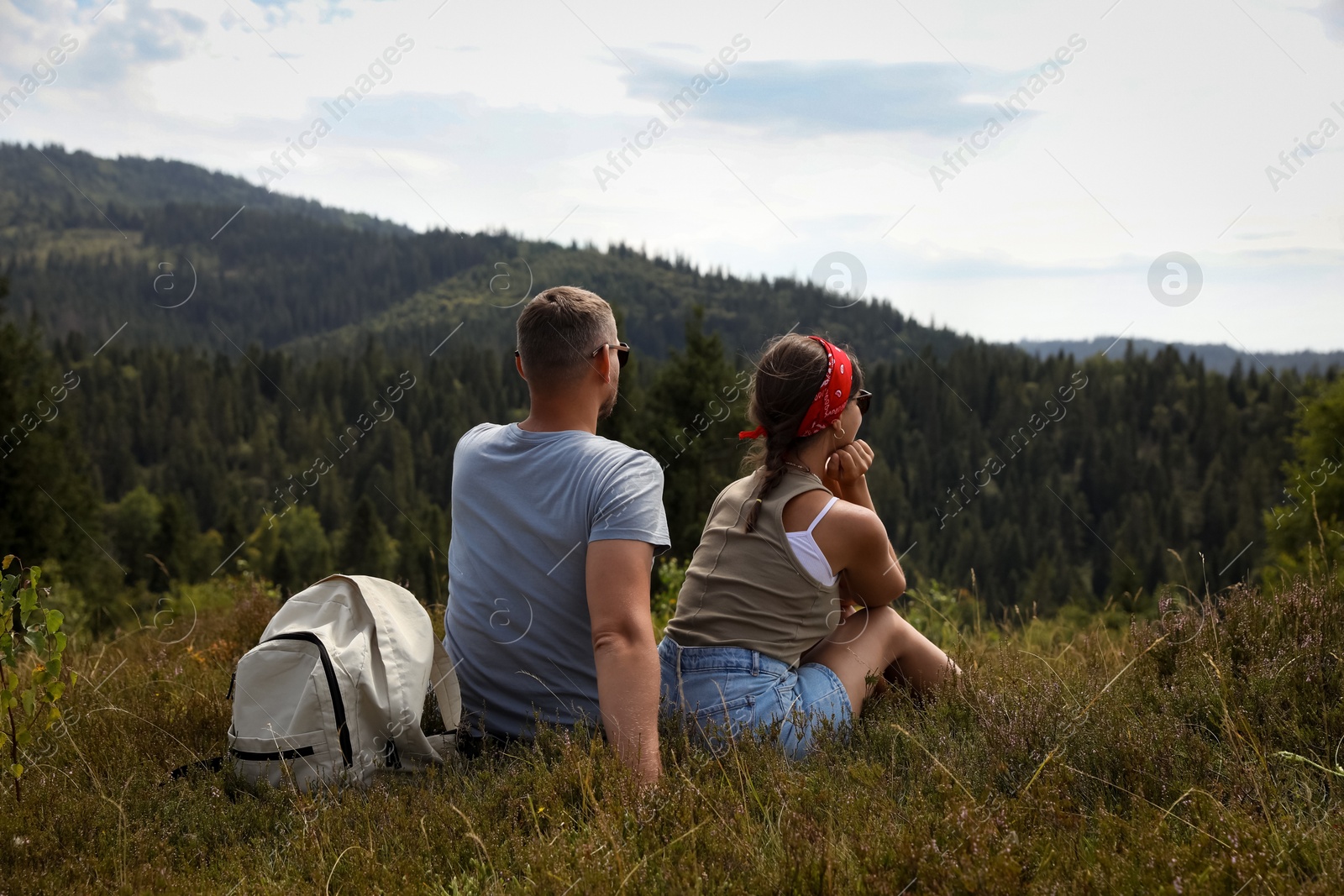 Photo of Couple with backpack enjoying picturesque landscape, back view. Active tourism