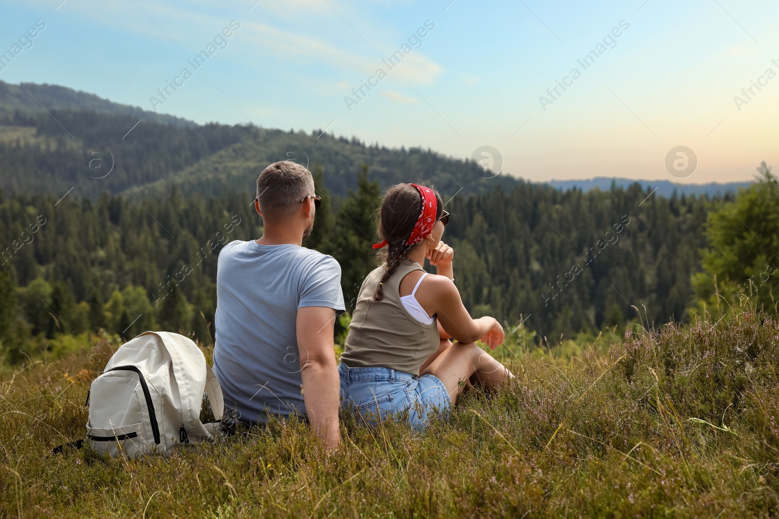 Photo of Couple with backpack enjoying picturesque landscape, back view. Active tourism