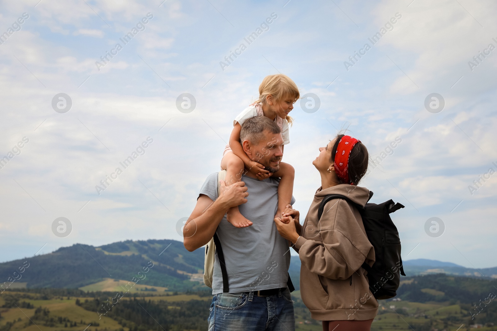 Photo of Family with backpacks travelling in mountains, space for text. Active tourism