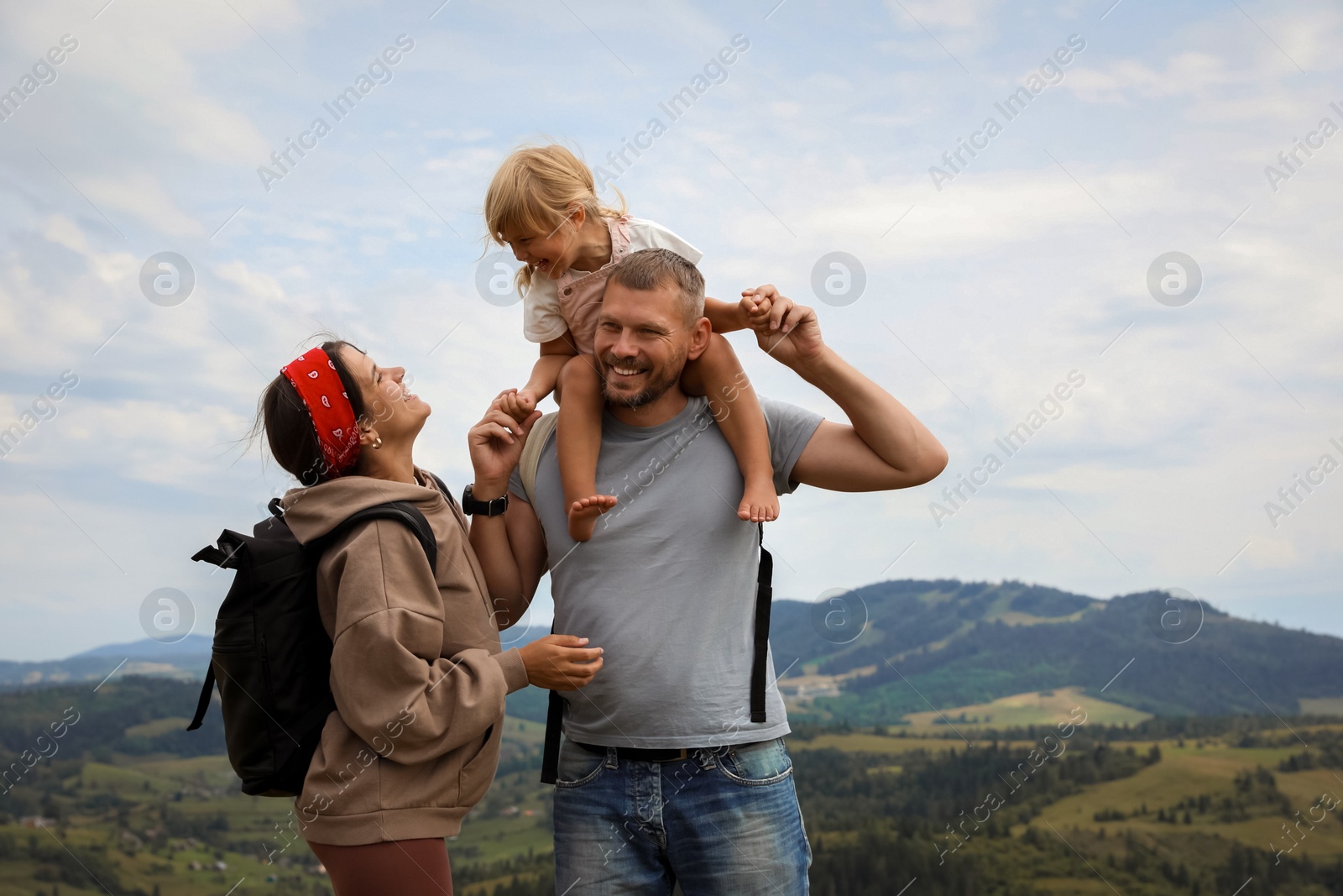 Photo of Happy family with backpacks travelling in mountains, space for text. Active tourism