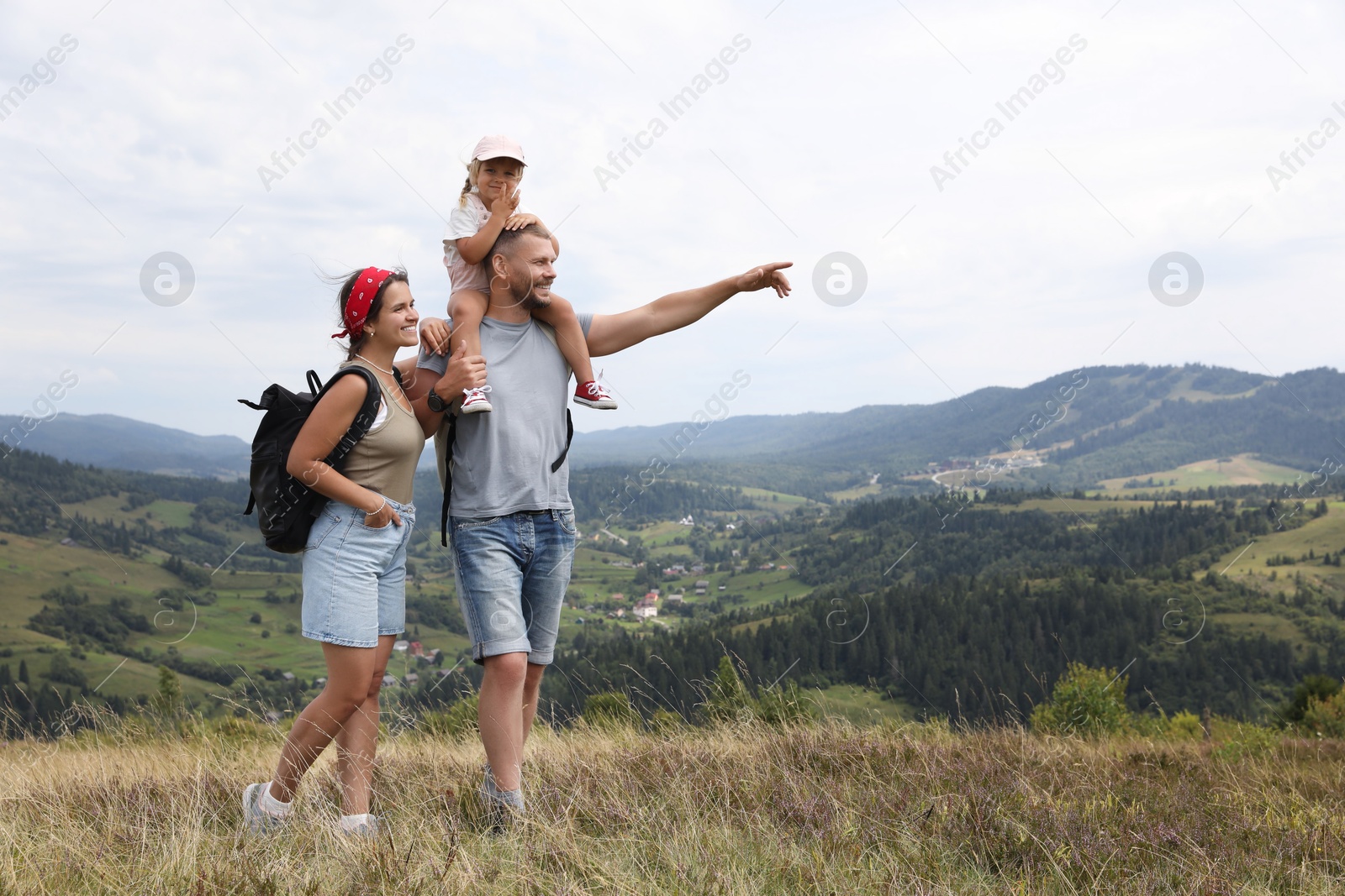 Photo of Happy family with backpacks travelling in mountains, space for text. Active tourism