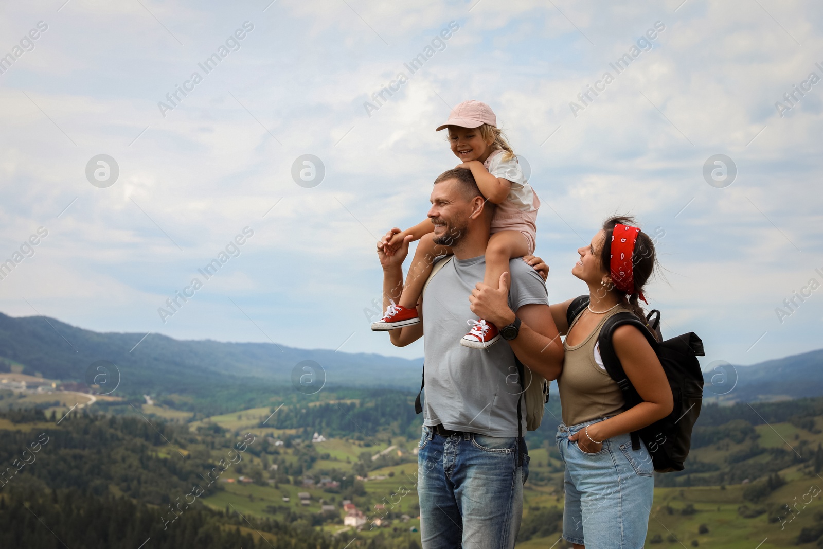 Photo of Happy family with backpacks travelling in mountains, space for text. Active tourism