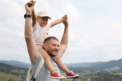 Photo of Happy tourist with his daughter and backpack travelling in mountains. Space for text