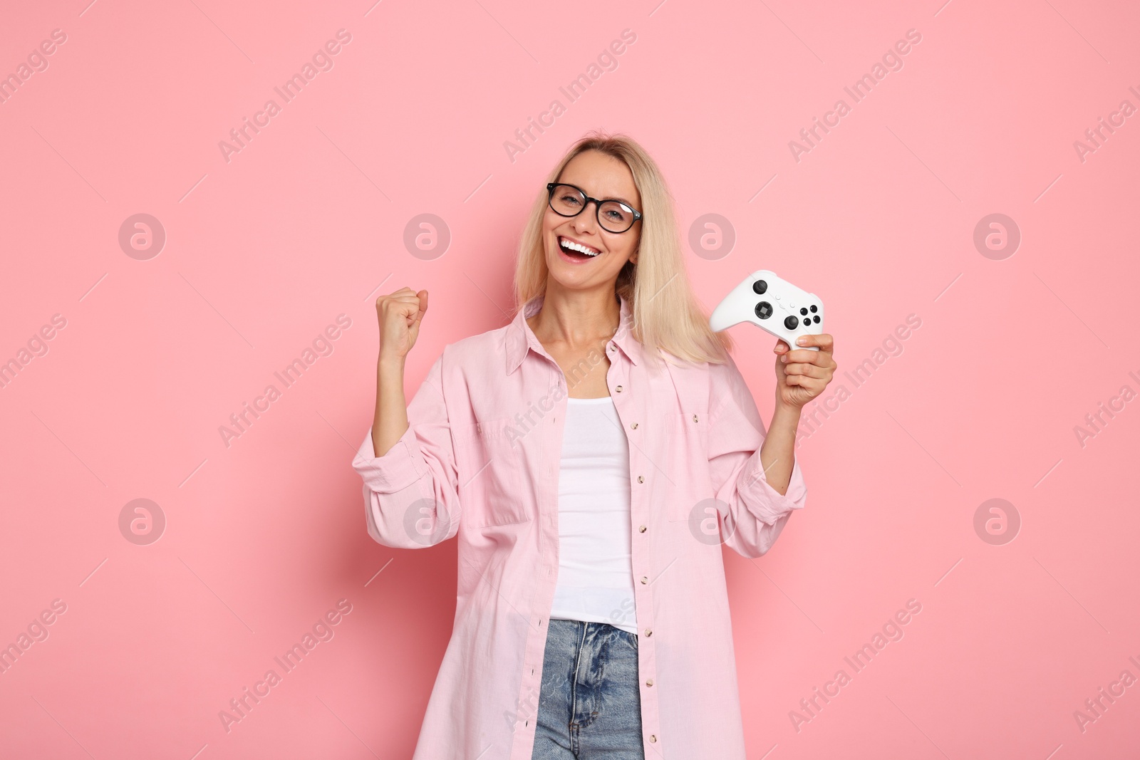 Photo of Happy woman with controller on pink background