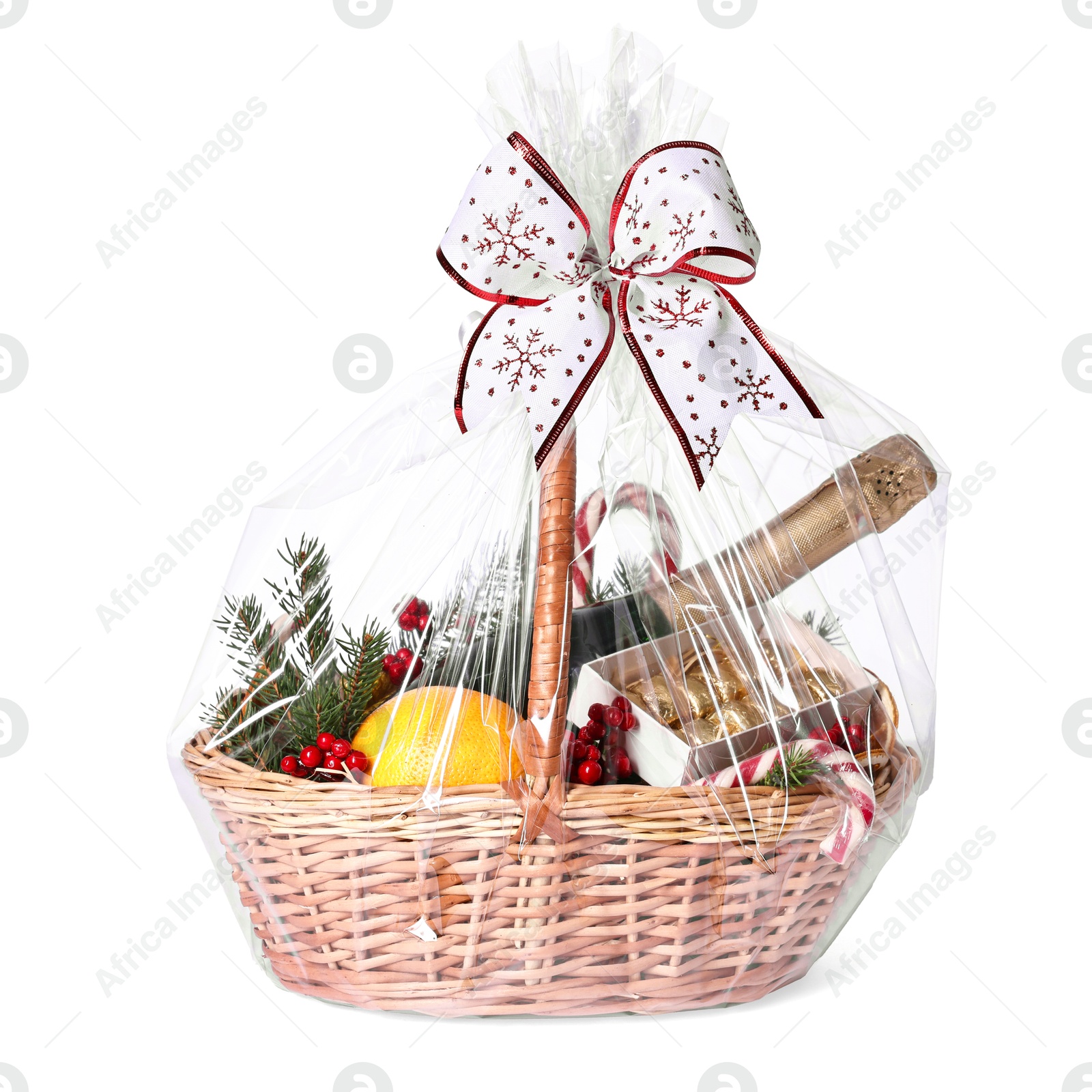 Photo of Wicker gift basket with sparkling wine and Christmas decor isolated on white