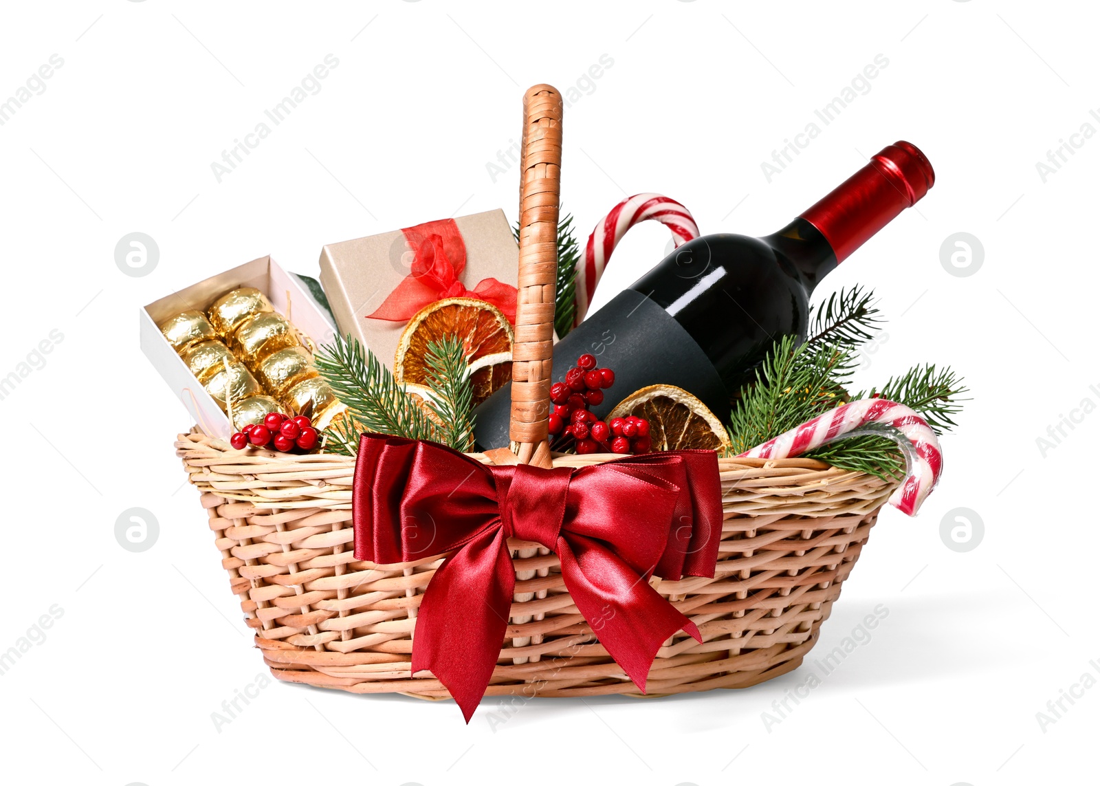 Photo of Wicker gift basket with wine and Christmas decor isolated on white