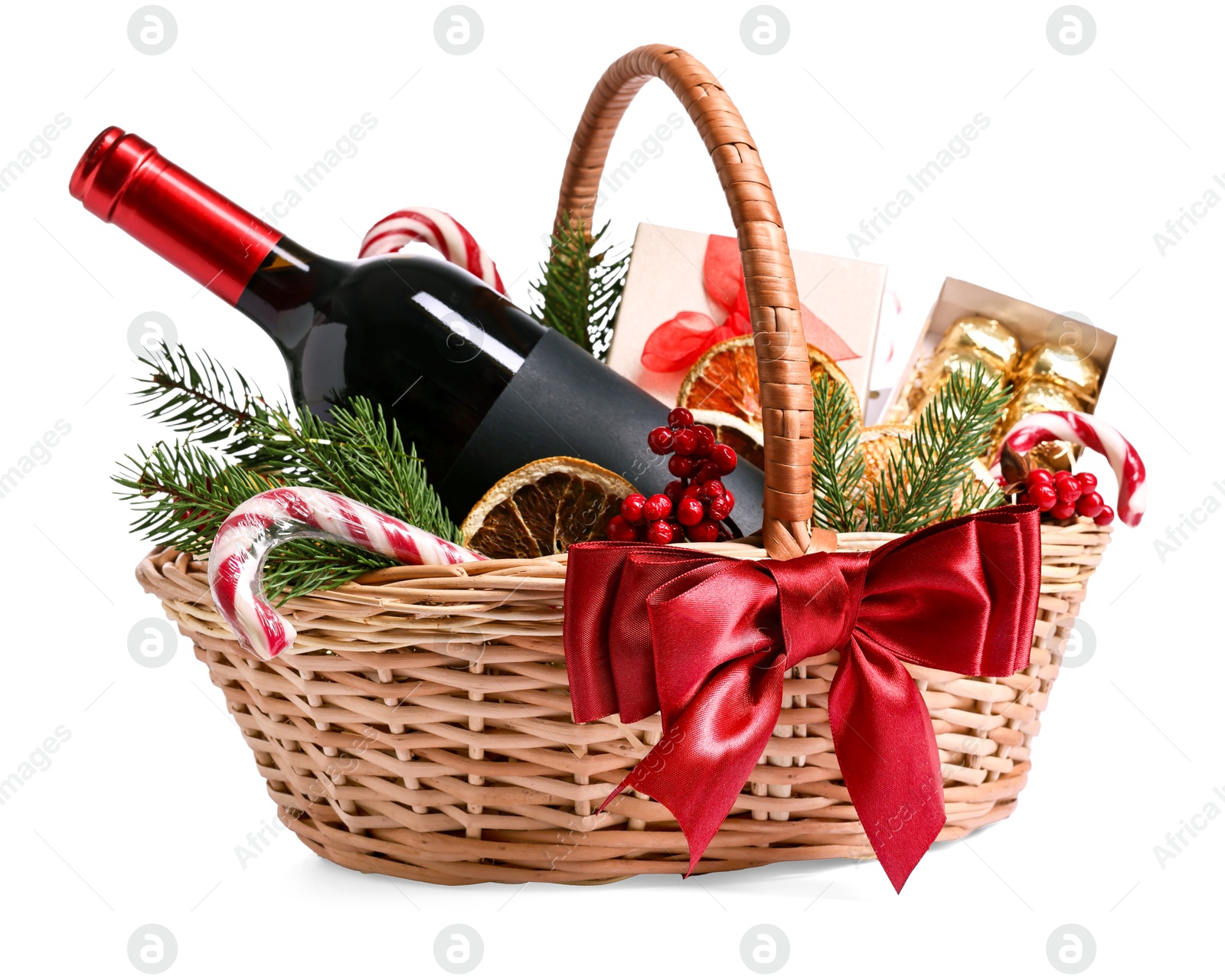 Photo of Wicker gift basket with wine and Christmas decor isolated on white