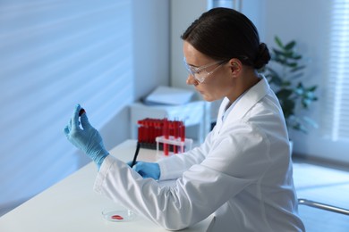 Photo of Laboratory testing. Doctor taking notes at table indoors