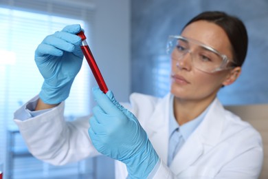 Laboratory testing. Doctor holding test tube with blood sample indoors, selective focus