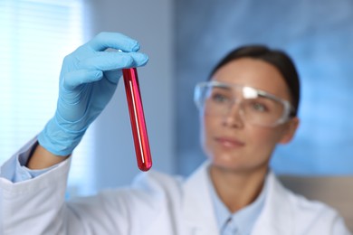 Photo of Laboratory testing. Doctor holding test tube with blood sample indoors, selective focus