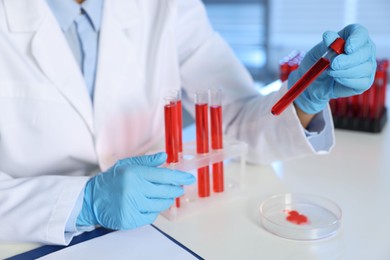 Photo of Laboratory testing. Doctor with blood samples at table indoors, closeup