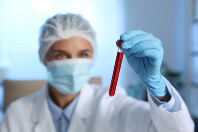 Laboratory testing. Doctor holding test tube with blood sample indoors, selective focus