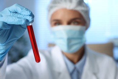 Laboratory testing. Doctor holding test tube with blood sample indoors, selective focus