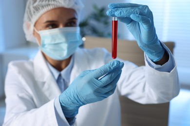 Photo of Laboratory testing. Doctor holding test tube with blood sample indoors, selective focus