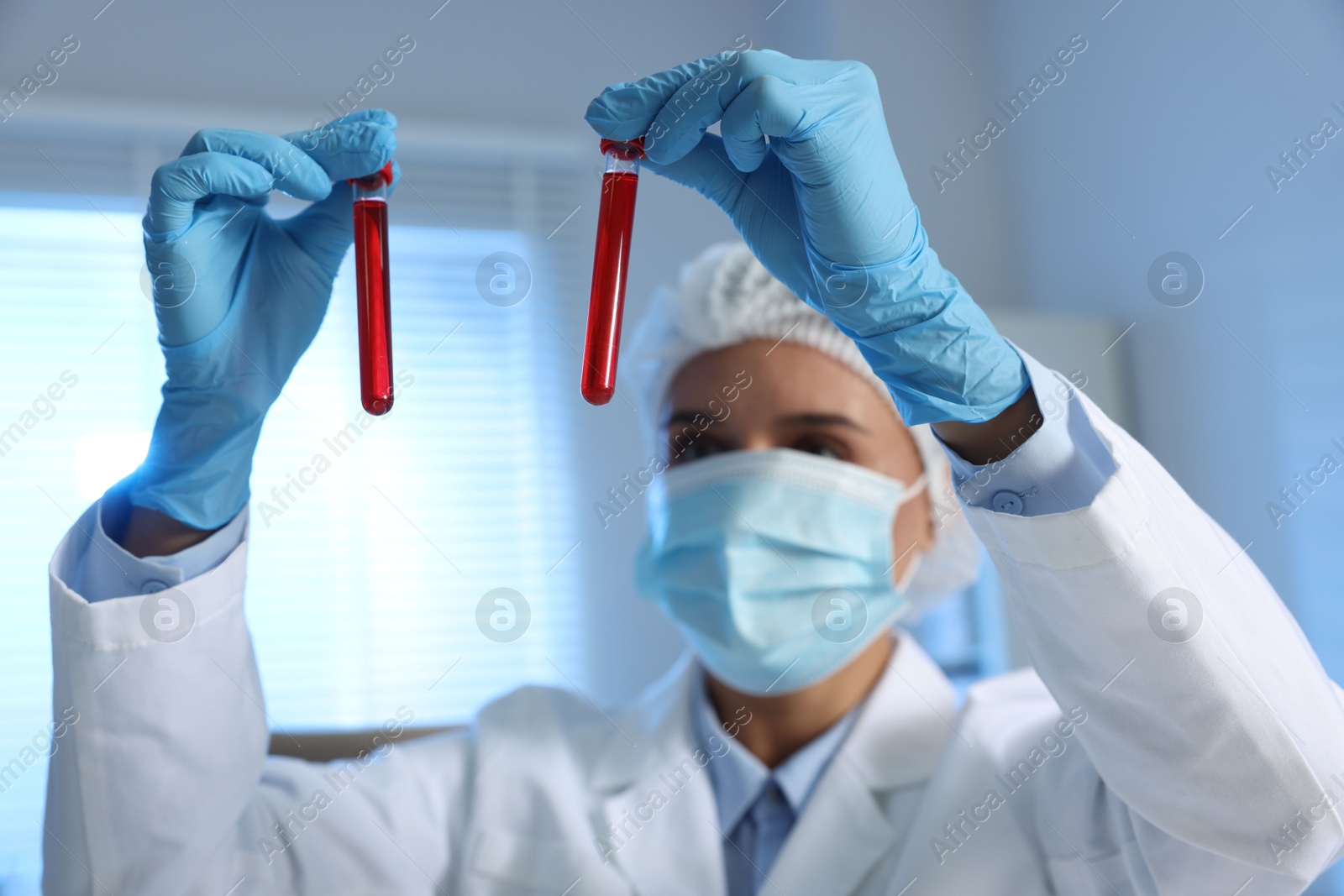 Photo of Laboratory testing. Doctor holding test tubes with blood samples indoors, selective focus