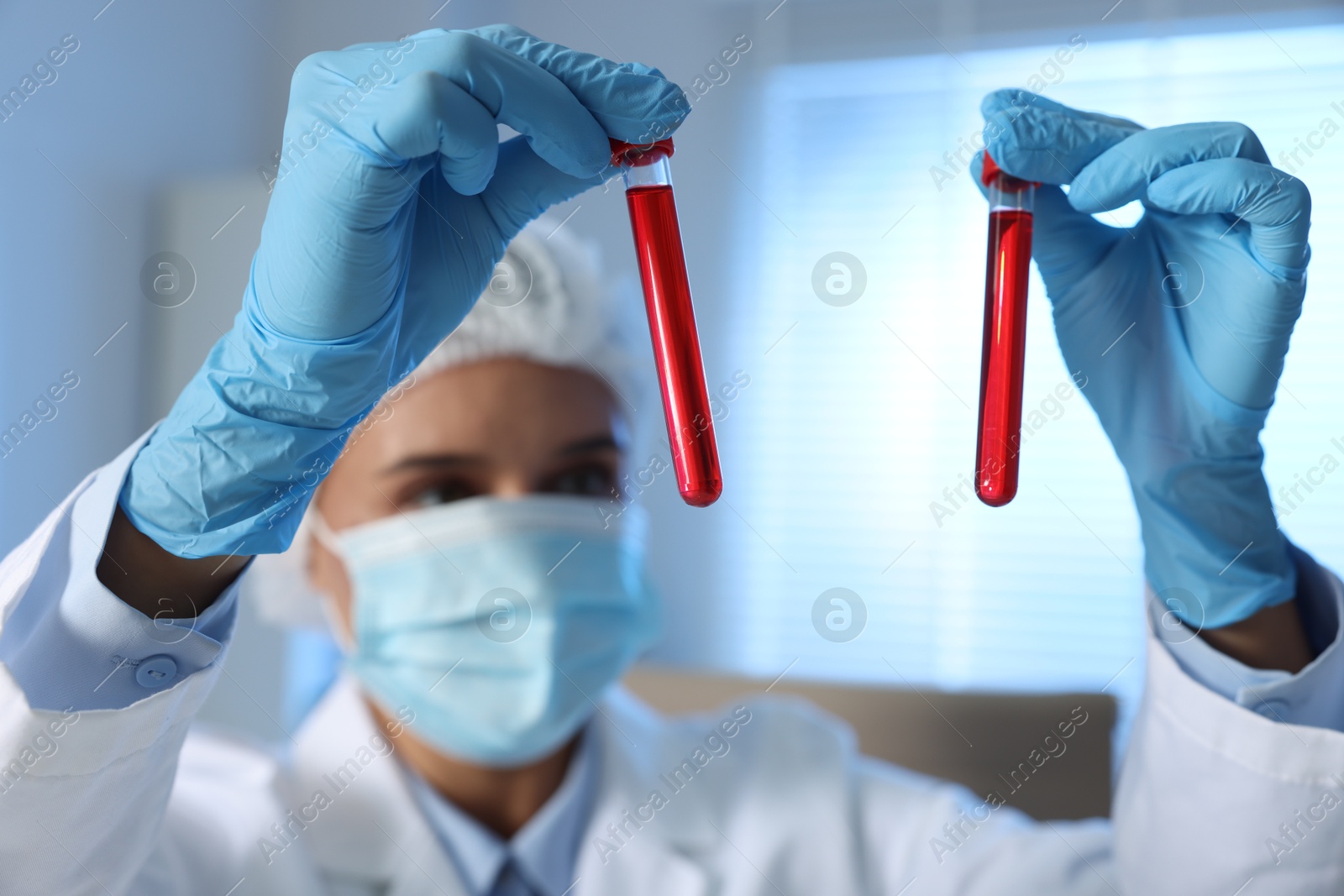 Photo of Laboratory testing. Doctor holding test tubes with blood samples indoors, selective focus