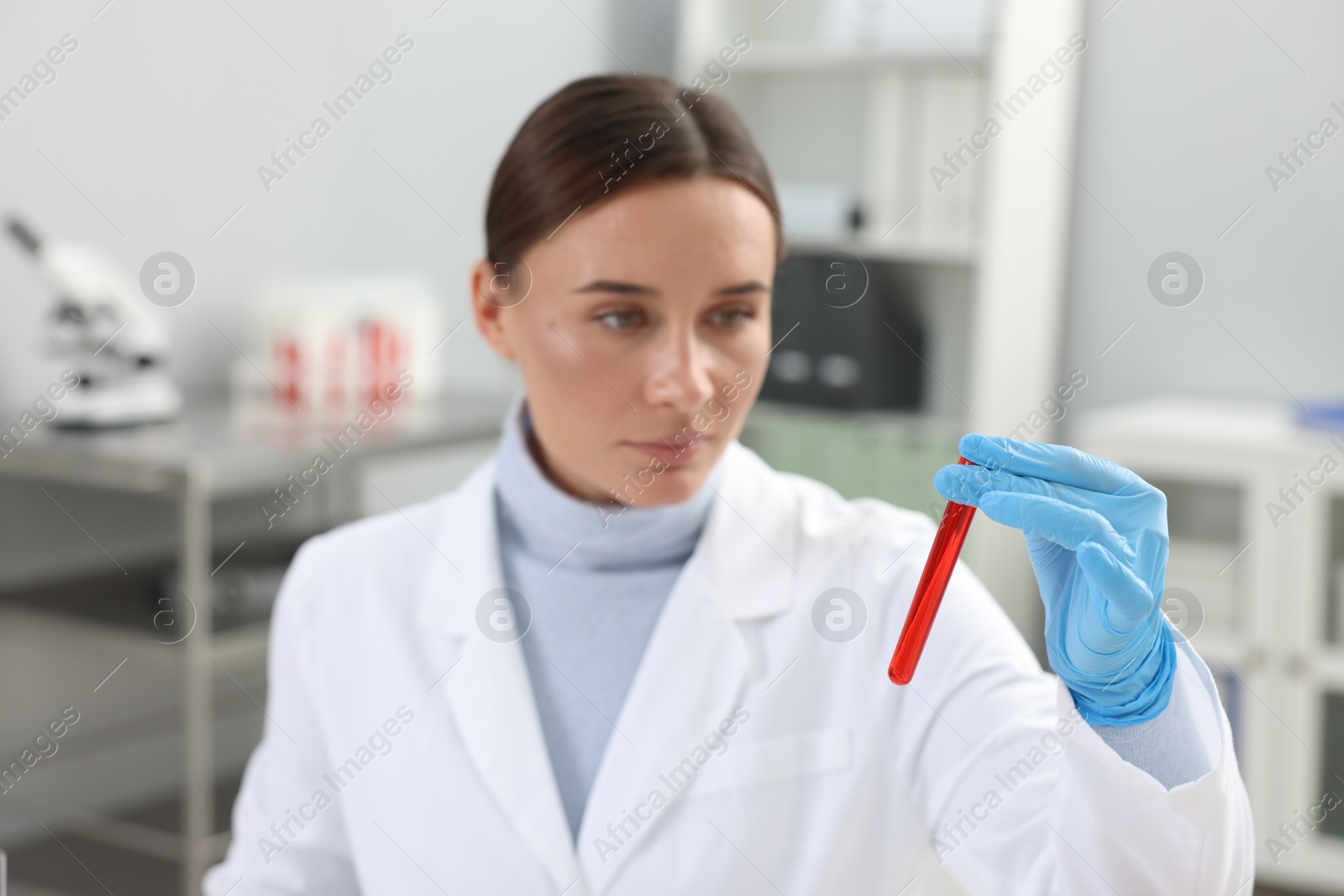 Photo of Laboratory testing. Doctor holding test tube with blood sample indoors, selective focus