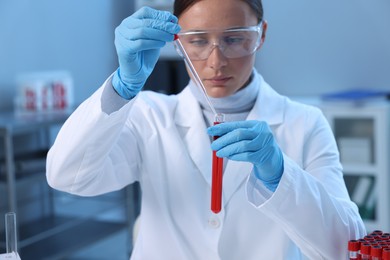 Laboratory testing. Doctor dripping blood sample into test tube indoors, selective focus