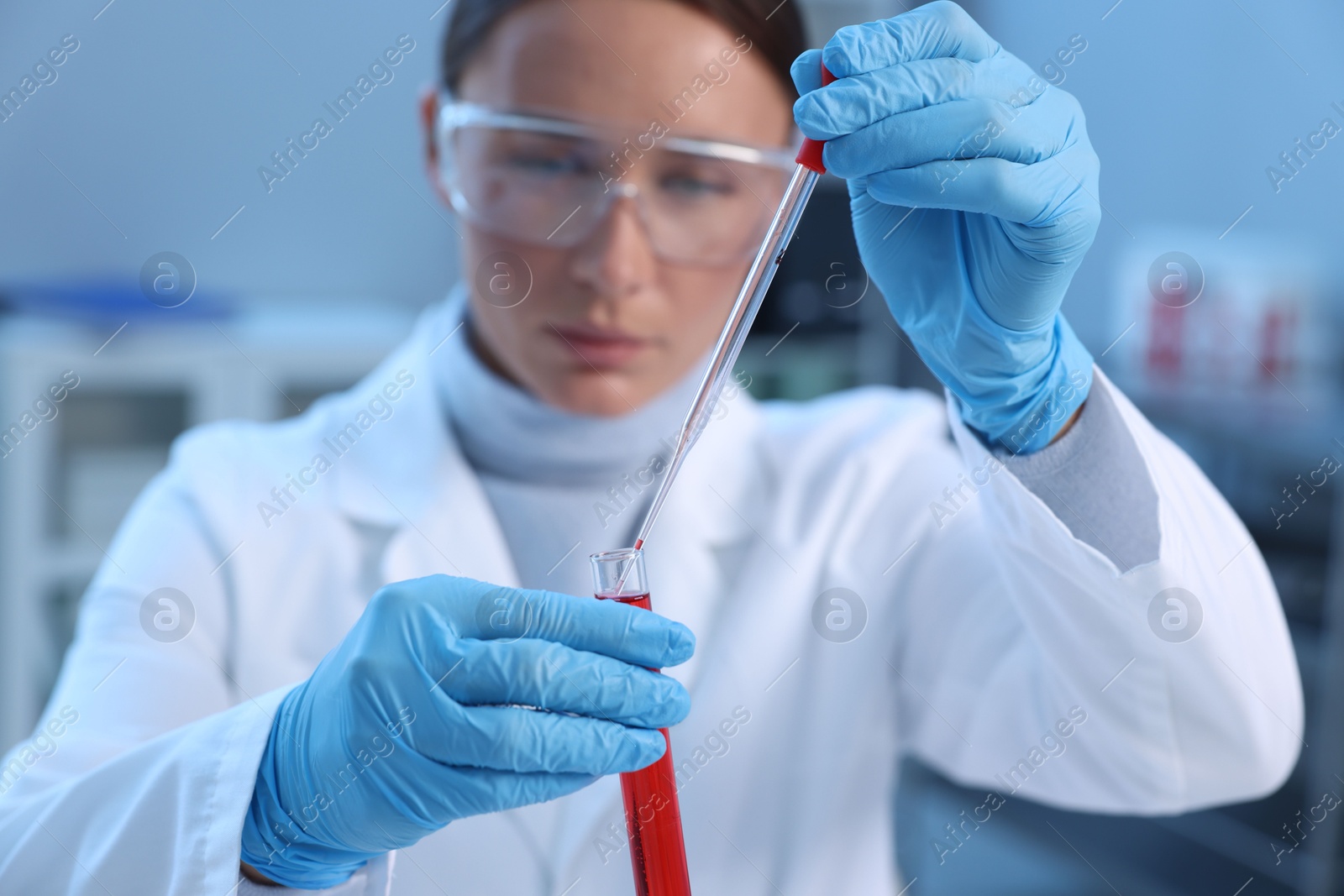 Photo of Laboratory testing. Doctor dripping blood sample into test tube indoors, selective focus